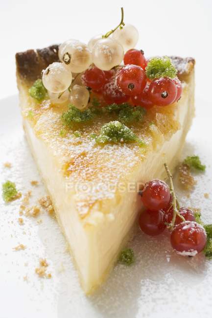 Trozo de pastel de queso con grosellas rojas - foto de stock