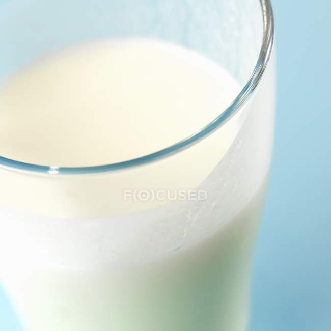 Закрыть молоко в стакане — стоковое фото