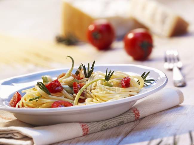 Espaguetis con tomates y romero - foto de stock