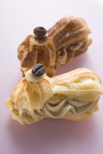 Крупним планом вид на еклери, наповнені вершками мокко та кавовими зернами — стокове фото