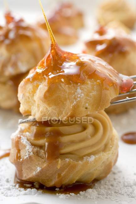 Closeup view of caramelized Profiterole with cream filling — Stock Photo