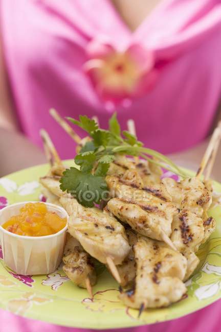 Closeup view of woman holding plate of Satay and Chutney — Stock Photo