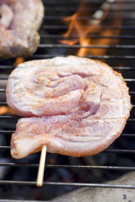 Carne de cerdo cruda en parrilla barbacoa - foto de stock