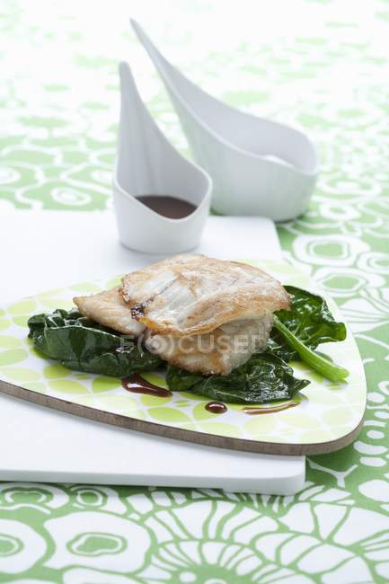 Branzino con gli spinaci (sea bass fillet on spinach) — Stock Photo