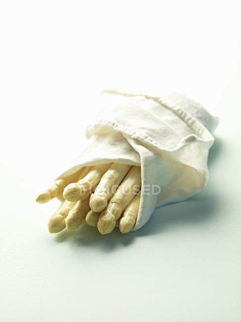 Espargos brancos envoltos em toalha kithcen — Fotografia de Stock