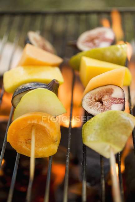 Vista de cerca de kebabs de frutas en parrilla de barbacoa - foto de stock