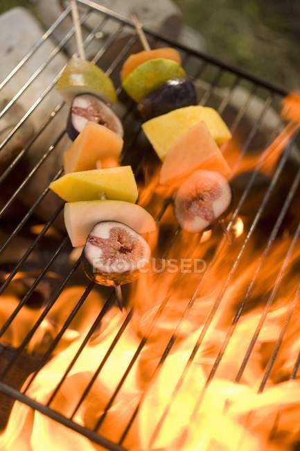 Vue rapprochée des kebabs de fruits sur grille barbecue — Photo de stock