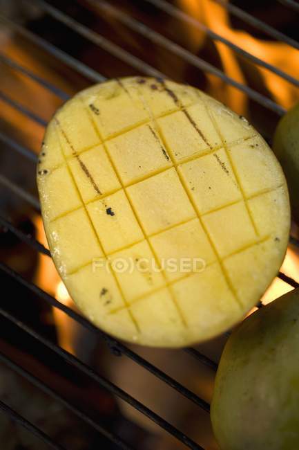 Mango on barbecue grill rack — Stock Photo