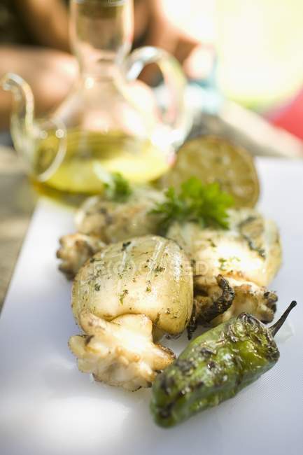 Жареная каракатица с чили на белой тарелке — стоковое фото