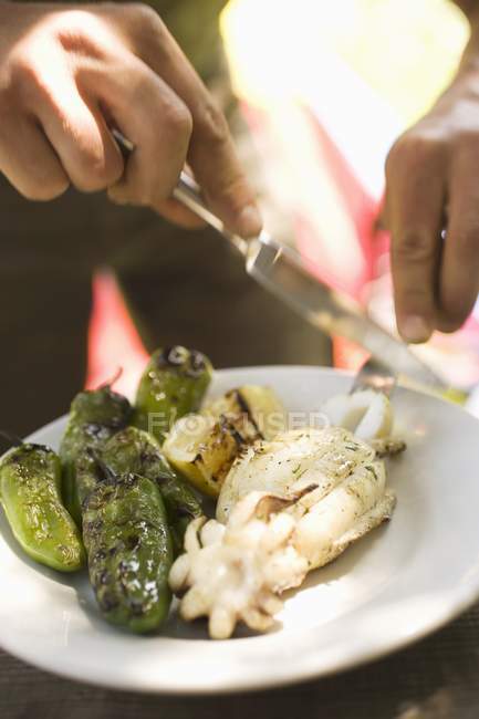 Uomo mangiare seppia alla griglia — Foto stock