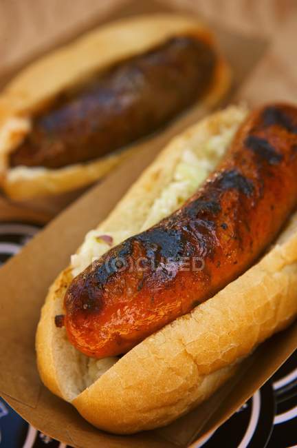 Closeup view of fried sausage on a bun in paper container — Stock Photo