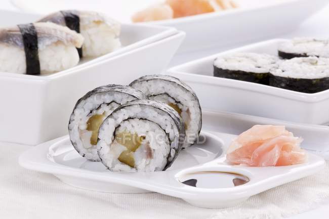 Maki y nigiri sushi con arenque y pepinillos - foto de stock
