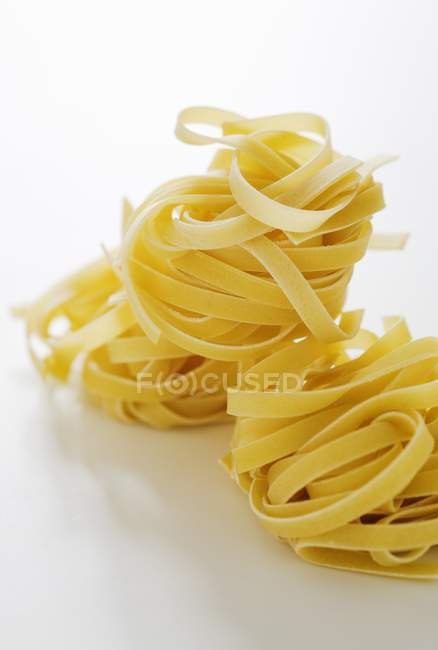 Raw tagliatelle pasta nests — Stock Photo