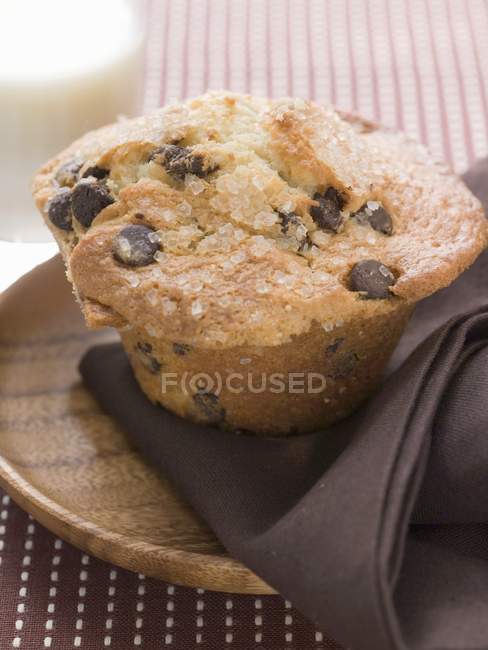 Chocolate chip muffin on wooden plate — Stock Photo