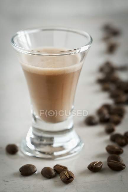 Vista close-up de licor de café e grãos de café — Fotografia de Stock