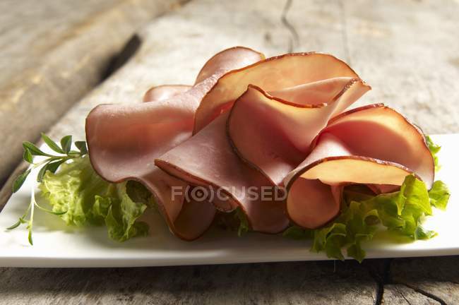 Turkey ham slices on salad leaves — Stock Photo