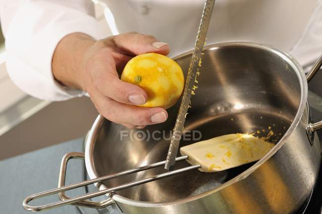 Nahaufnahme abgeschnittene Ansicht von Person, die Zitrone reibt — Stockfoto