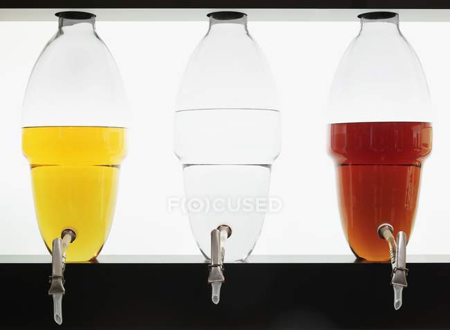 Closeup view of different colored spirits in glass containers — Stock Photo