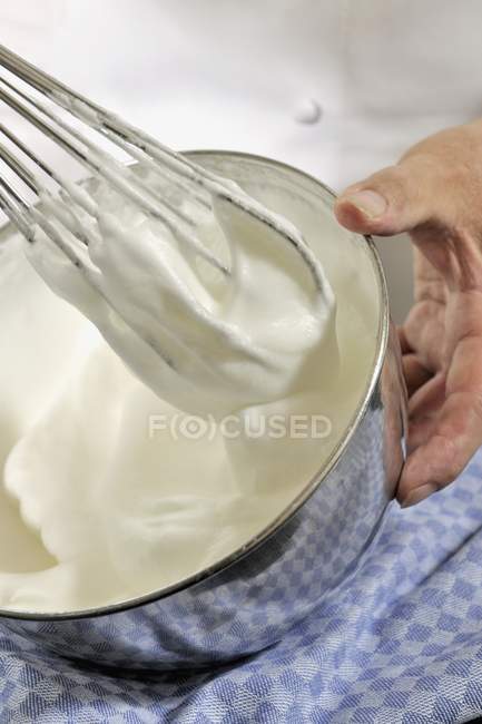 Closeup view of whisking egg white and sugar in metal bowl — Stock Photo