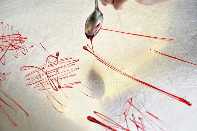 Elevated view of hand making spun sugar with spoon on metal surface — Stock Photo
