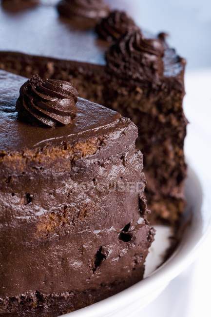 Bolo de chocolate parcialmente fatiado — Fotografia de Stock