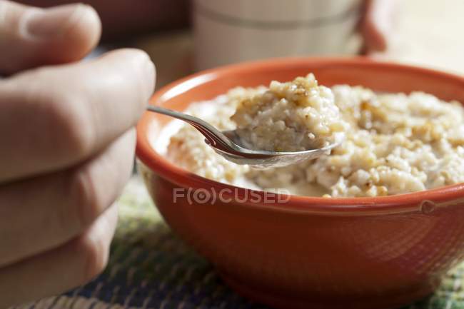 Hand Holding a Spoonful of Oatmeal — Stock Photo