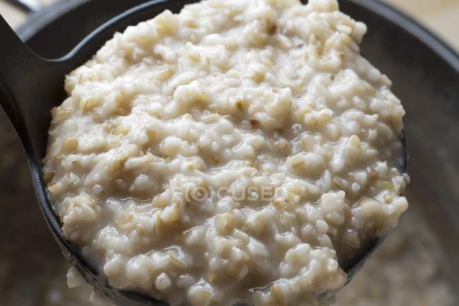 Closeup view of a ladle of cooked oatmeal — Stock Photo