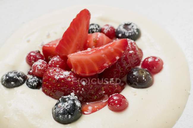 Вид крупным планом ванильного крема с ягодами на тарелке — стоковое фото