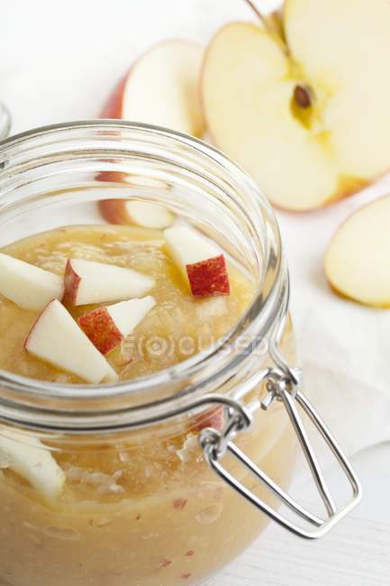 Vista de cerca de la salsa de manzana con trozos de manzana fresca - foto de stock