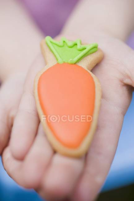 Manos de niño sosteniendo galleta de Pascua - foto de stock
