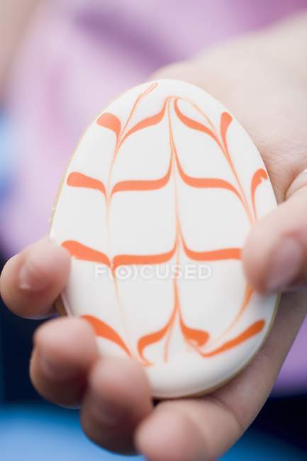 Child hand holding Easter biscuit — Stock Photo