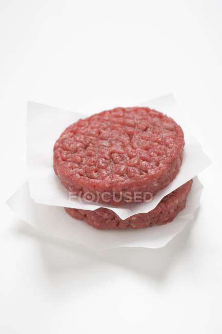 Hambúrgueres crus em papel — Fotografia de Stock