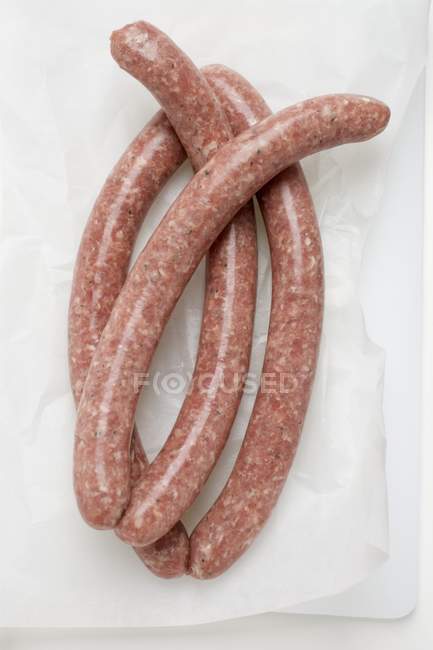 Raw sausages on paper — Stock Photo