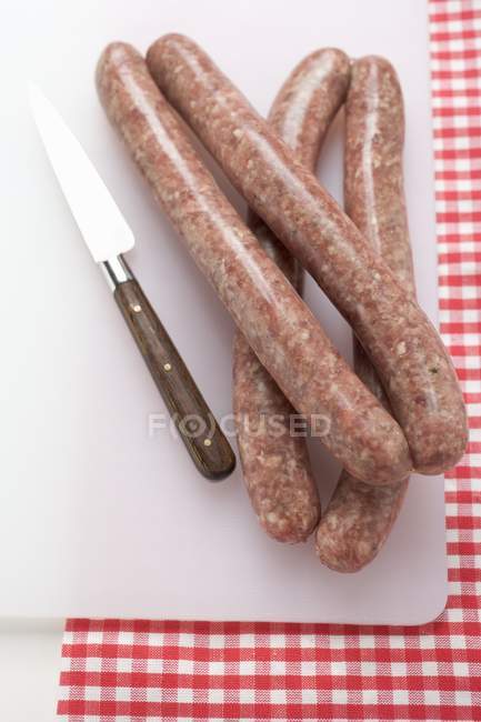Sausages on chopping board — Stock Photo