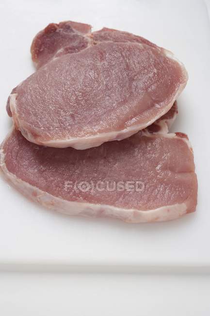 Свежие свиные стейки — стоковое фото