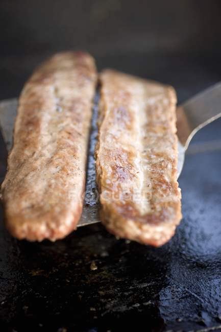 Saucisse de porc frite sur spatule — Photo de stock