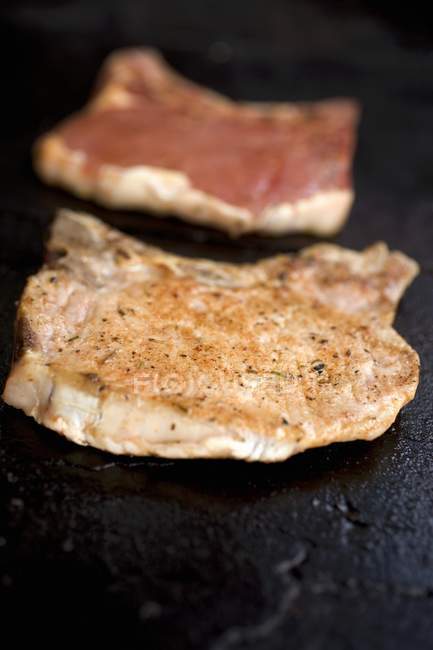 Fried and raw Pork chops — Stock Photo