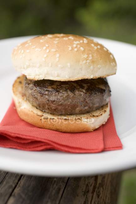 Hamburger on plate with red tissue — Stock Photo