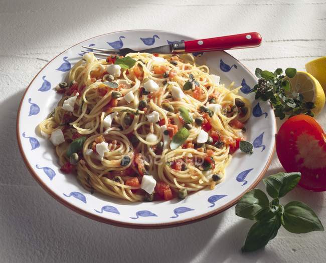 Espaguetis con tomates y mozzarella - foto de stock