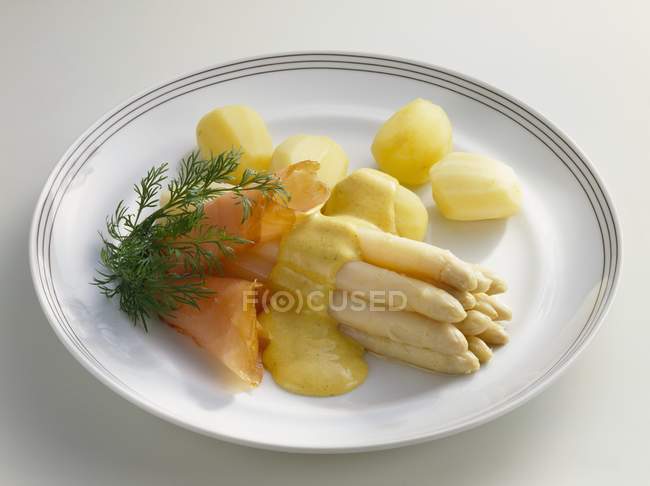 Asparagus with curry sauce and smoked salmon — Stock Photo