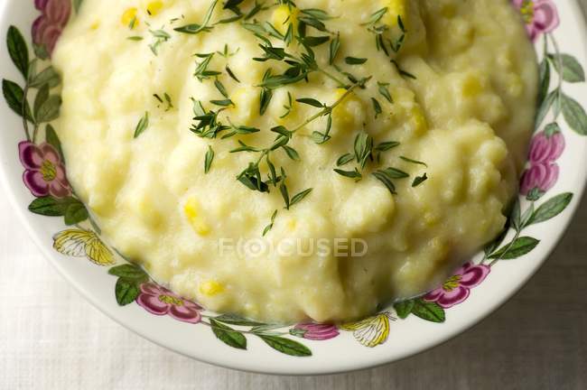 Closeup view of cream corn Polenta with fresh thyme in a bowl — Stock Photo