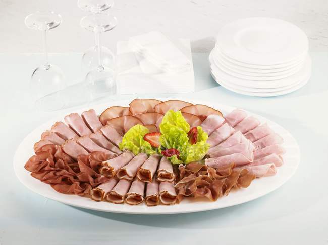 Platter with sliced ham — Stock Photo