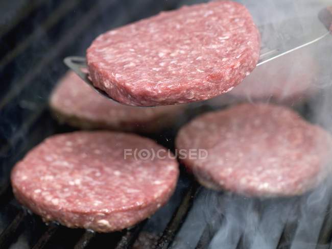 Grilling fresh beef burgers — Stock Photo