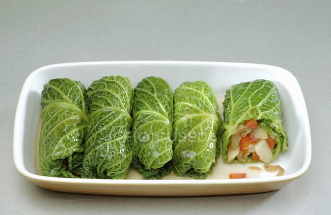 Hojas de col rizada rellenas con relleno vegetal en plato blanco - foto de stock