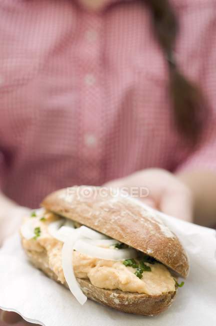 Woman holding bread roll — Stock Photo