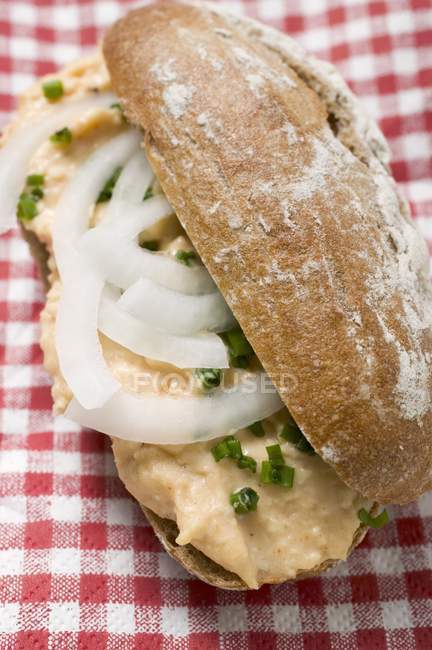 Bread roll on checked cloth — Stock Photo