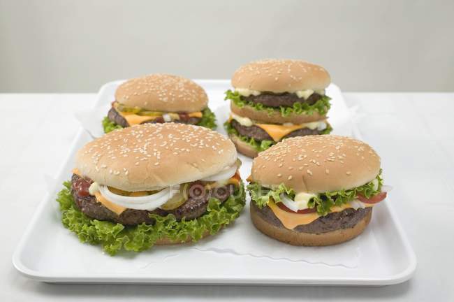 Four cheeseburgers on tray — Stock Photo