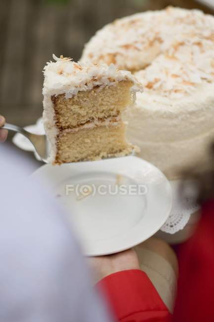 Woman holding piece of coconut cake — Stock Photo