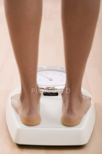 Vista ritagliata di gambe femminili in piedi su bilance da bagno — Foto stock