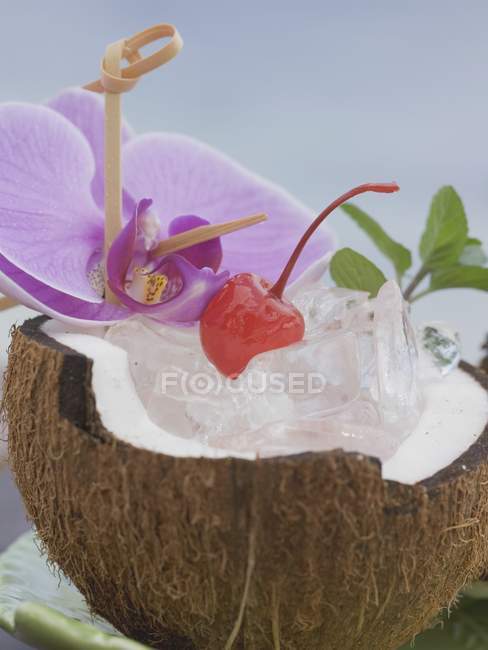 Noce di cocco aperta con menta e orchidea — Foto stock